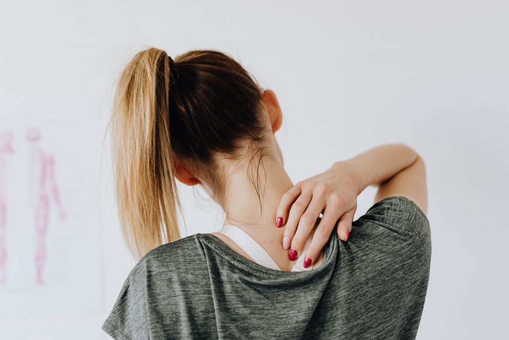 image of young lady with back pain holding her neck